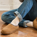 Close-up of BEARPAW Men's Beau Clog in Hickory worn with white socks and jeans for a casual, relaxed everyday look.