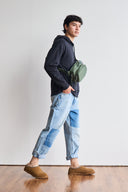 Model wearing BEARPAW Men's Beau Clog in Hickory with casual jeans, showing the slip-on clog in a relaxed everyday outfit.