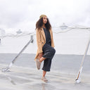 Model wearing BEARPAW Women's Calista Clog in Toffee in a rooftop lifestyle setting with relaxed casual styling.
