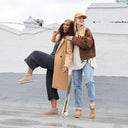 Model wearing BEARPAW Women's Langly boots in a rooftop setting with casual fall styling, highlighting the relaxed everyday silhouette.