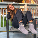 Model wearing BEARPAW Women's Alyssa Boot in Graphite with a casual fall outfit, highlighting cozy everyday cold-weather styling.