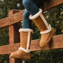 Close-up of BEARPAW Women's Kendall Boot in Hickory worn on foot as part of a casual fall and winter outfit.