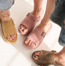Bearpaw Frances platform sandals in multiple colors, shown on foot in a lifestyle setting highlighting soft materials, buckle detail, and everyday comfort.